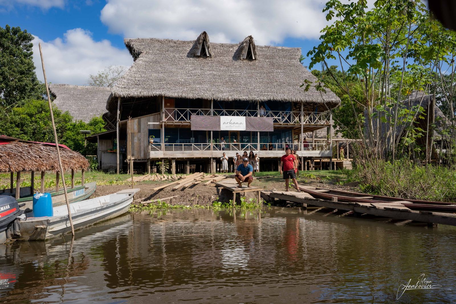The Amazon lodge on stilts above the river, with canoes moored below