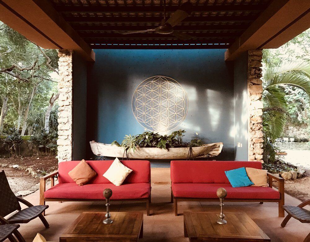 An open-air lounge with a flower-of-life mural