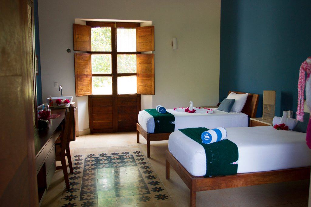 A twin room with a patterned tile floor