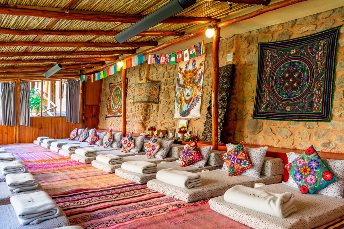 Inside the Sacred Valley ceremonial temple, cushions laid out beneath Andean textiles